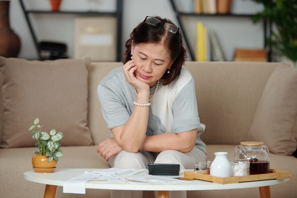 Pensive woman paying bills